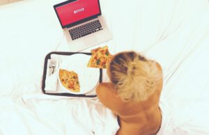 Kobieta leżąca na łóżku oglądająca Netflix