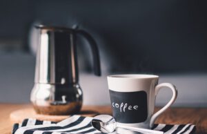 Kubek z kawą obok kawiarki