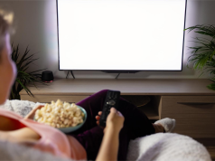 Kobieta wybiera film na telewizorze