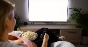 Kobieta wybiera film na telewizorze