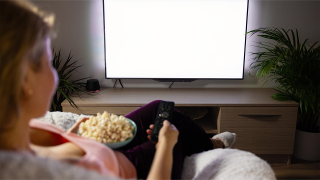 Kobieta wybiera film na telewizorze